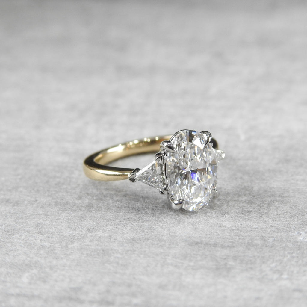 oval diamond ring with trillion side diamonds